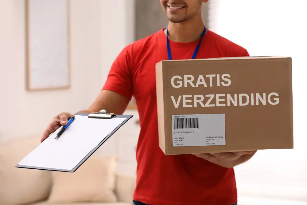 Cardboard verzenddoos gelabeld 'GRATIS VERZENDING' die naast een clipboard wordt gehouden.